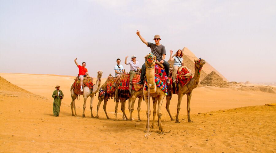 Pictures of some tourists riding camels in the pyramids area