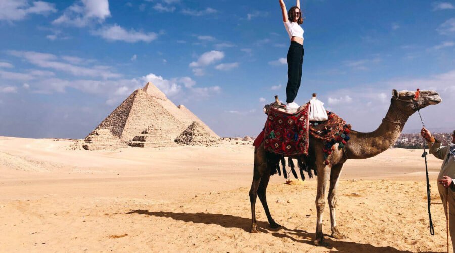 great shot of a female tourist standing on a camel