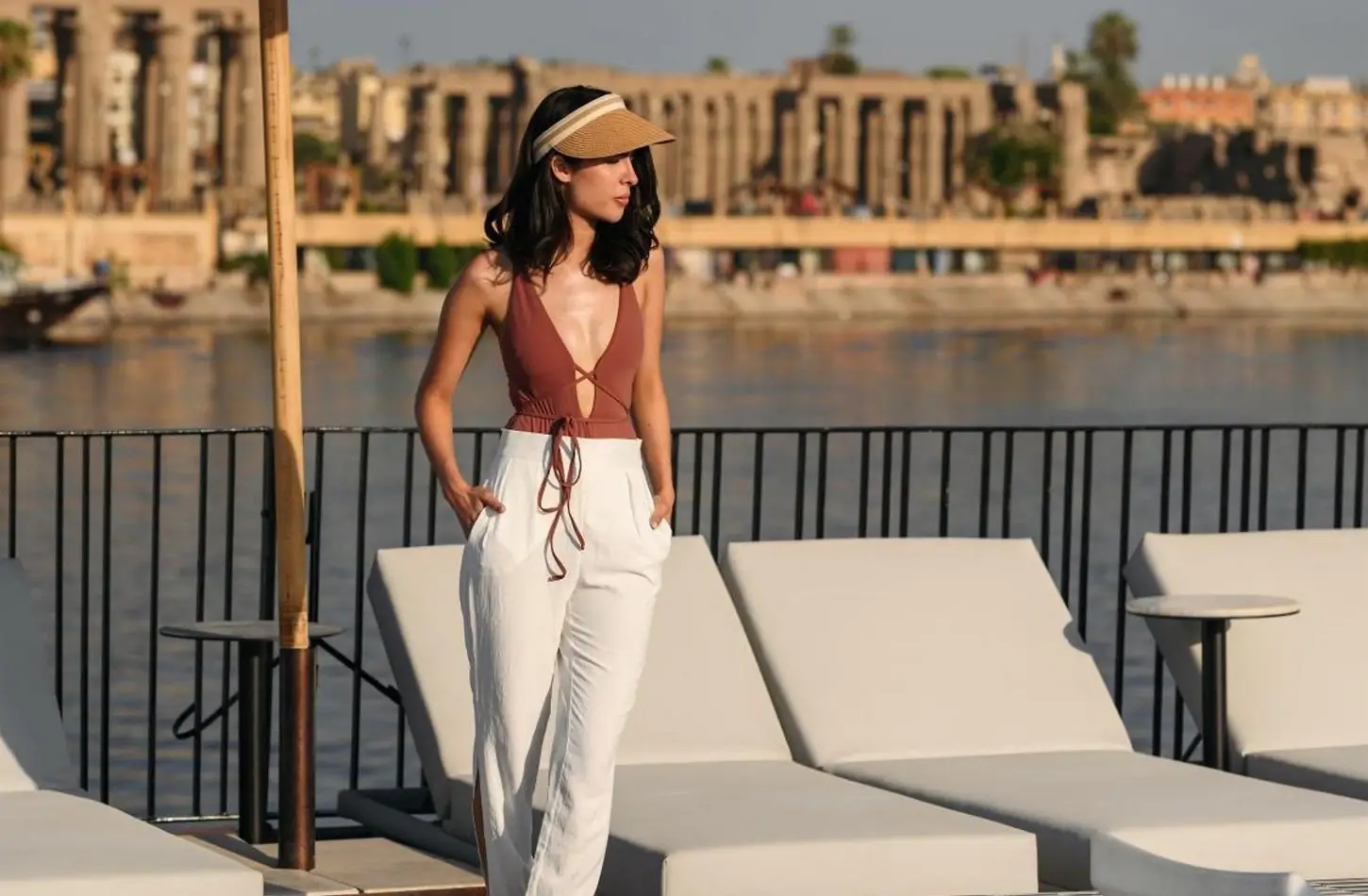 Woman on a luxury Nile cruise ship deck with an ancient Egyptian temple in the background.