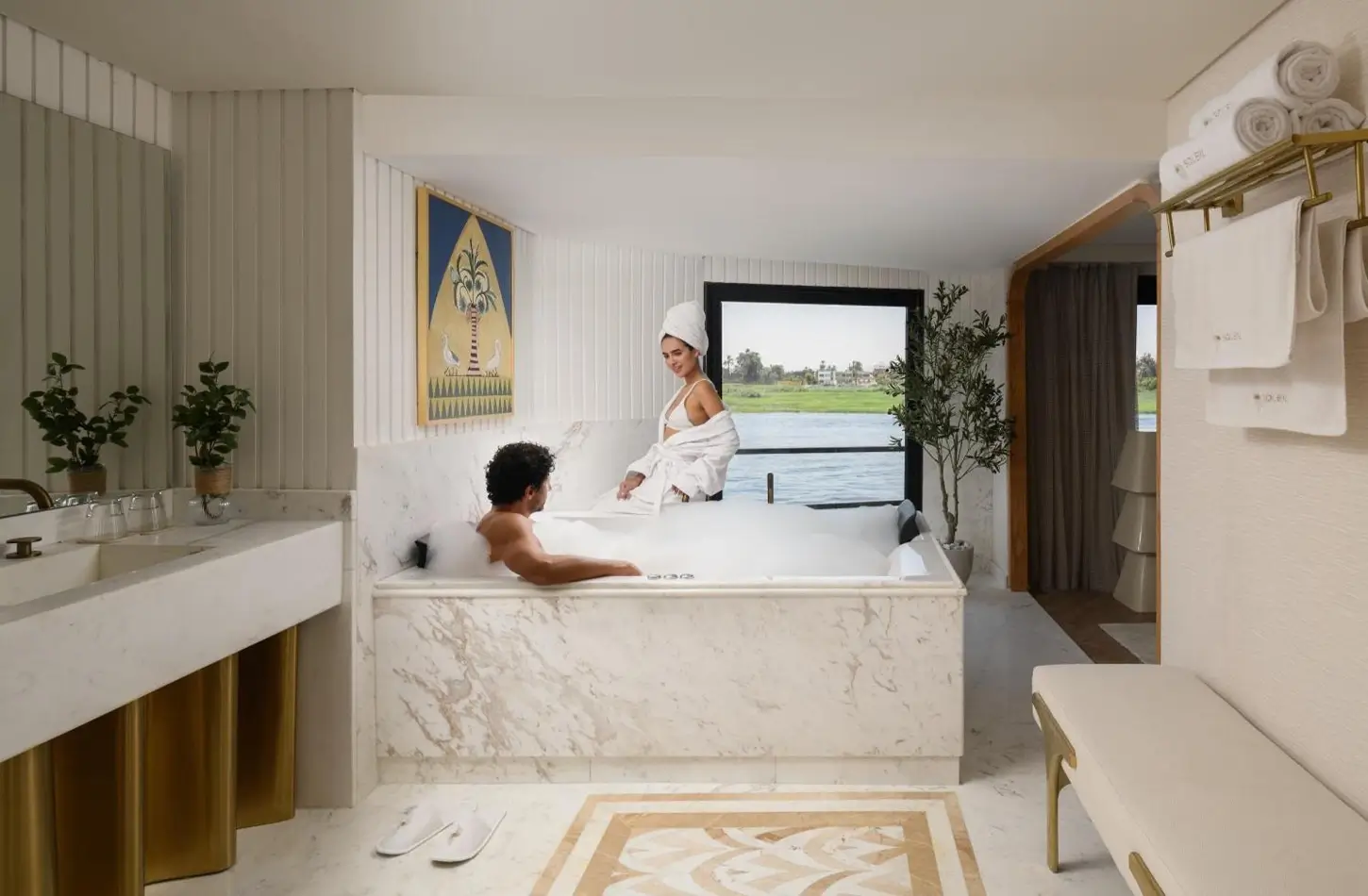 A couple in a marble jacuzzi inside a luxury Nile cruise cabin overlooking the river.