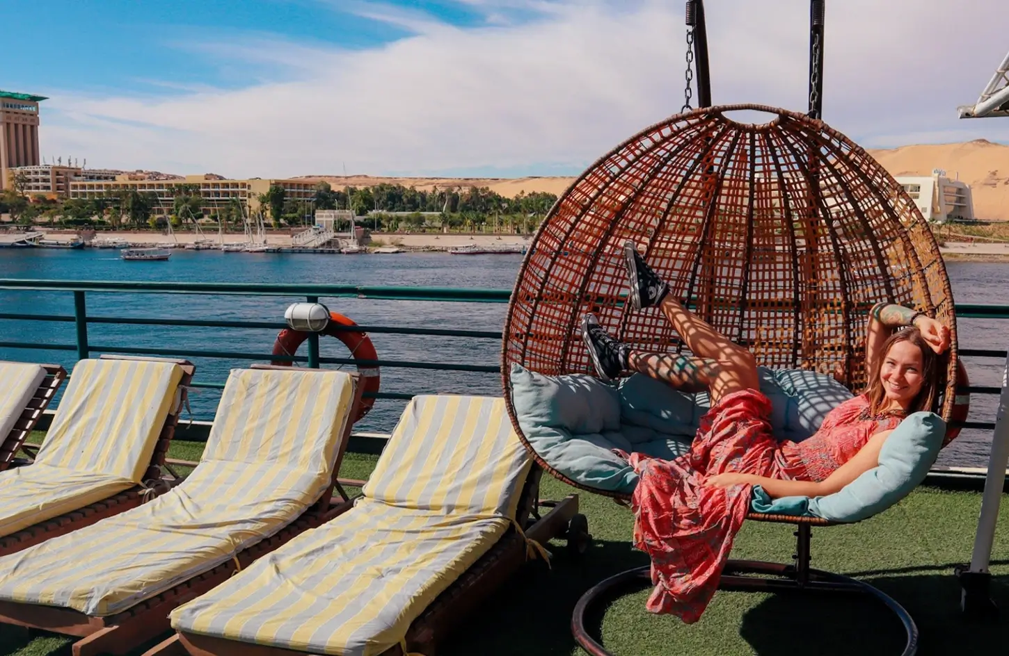 Tourist relaxing in a hanging egg chair on the sun deck of a Nile River cruise ship.