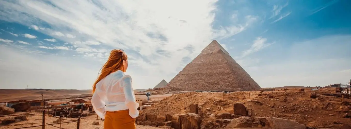 A solo female traveler looking at the Great Pyramid of Giza, a highlight of any Egypt itinerary 7 days.