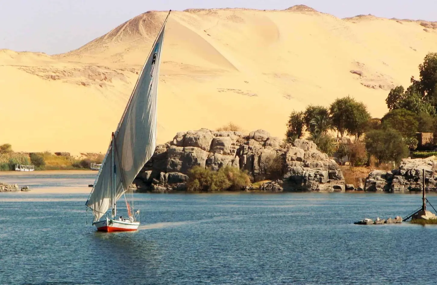 A traditional wooden felucca boat sailing on the Nile River in Aswan during a vacation to Egypt in November.
