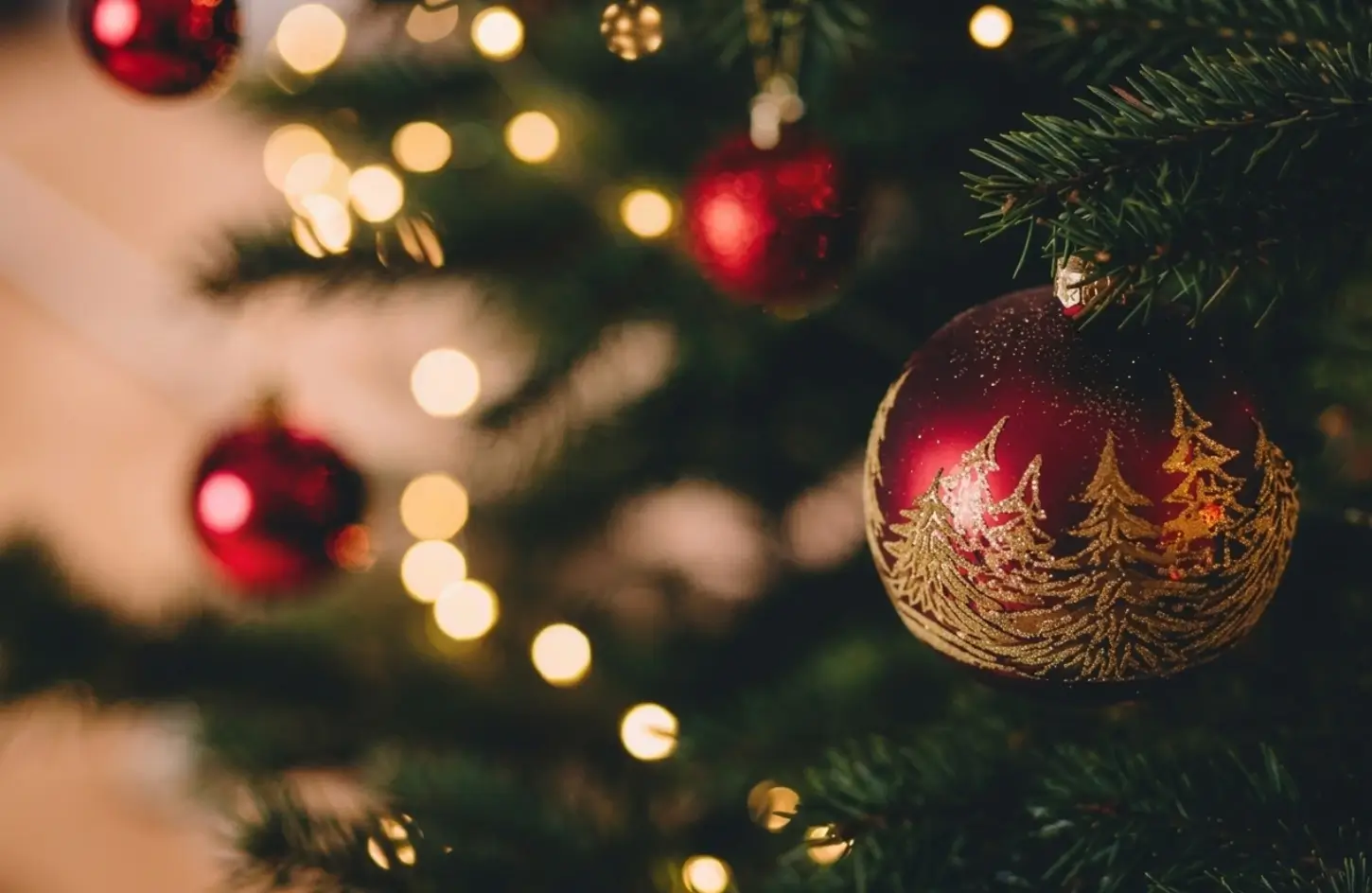 Close-up of a red and gold Christmas tree ornament with warm bokeh lights during Egypt Christmas Tours